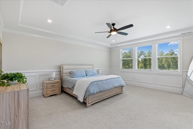 bedroom featuring crown molding, a raised ceiling, light colored carpet, and ceiling fan