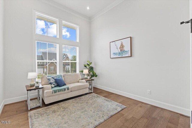 living room featuring ornamental molding and wood-type flooring