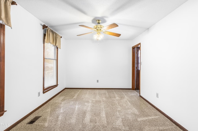 carpeted spare room with ceiling fan