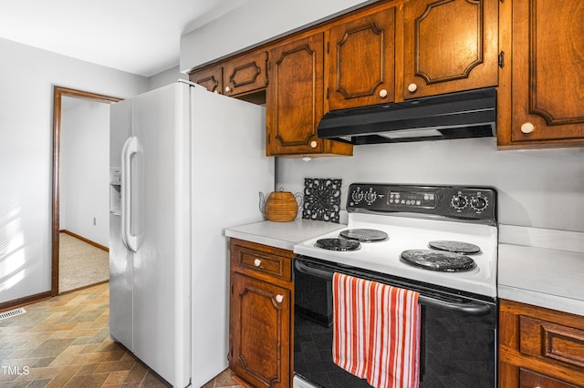 kitchen with electric range oven and white fridge with ice dispenser