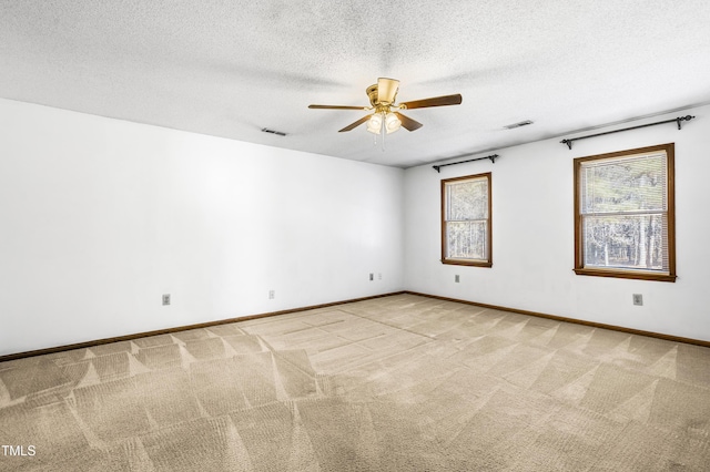 unfurnished room featuring a textured ceiling, light colored carpet, and ceiling fan