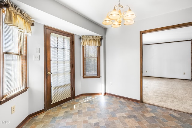 interior space featuring an inviting chandelier and carpet floors