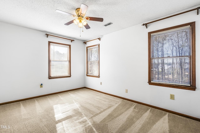 carpeted spare room with a textured ceiling and ceiling fan