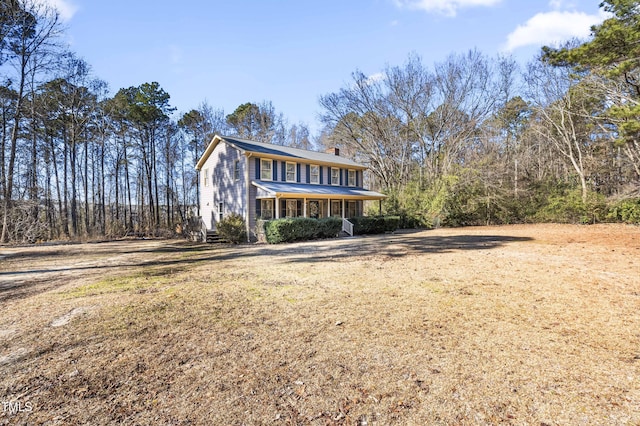 front of property with covered porch and a front yard