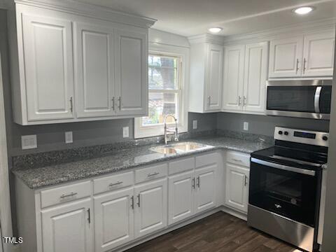 kitchen featuring sink, stainless steel appliances, white cabinets, and dark hardwood / wood-style flooring