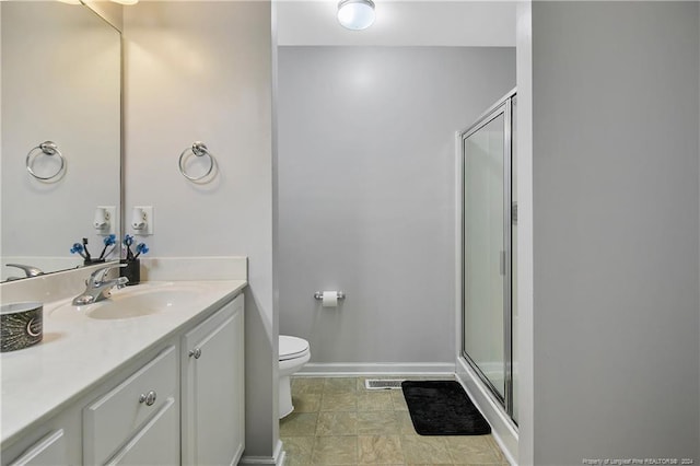 bathroom with a shower with door, vanity, and toilet