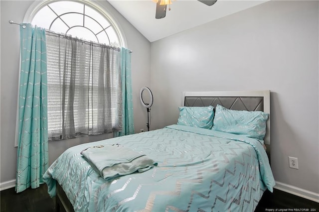 bedroom featuring dark hardwood / wood-style flooring, vaulted ceiling, and ceiling fan