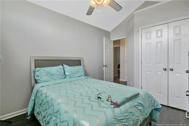 bedroom with lofted ceiling, dark hardwood / wood-style flooring, ceiling fan, and a closet