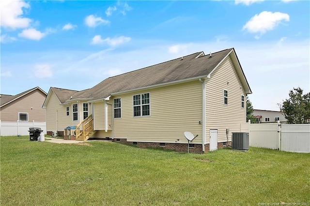 rear view of property featuring a yard and central AC