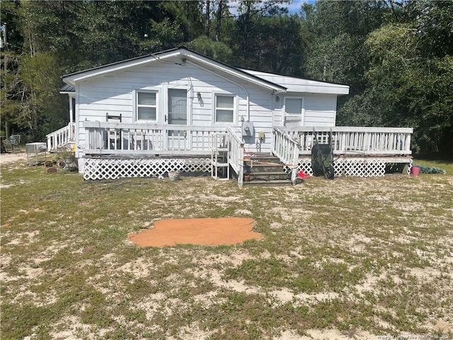 rear view of house featuring a wooden deck and a lawn