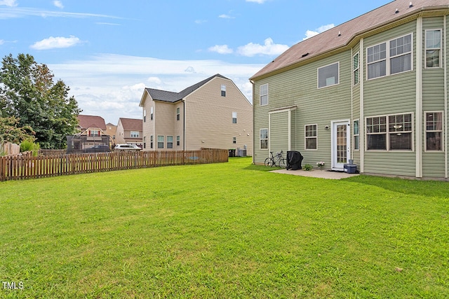 rear view of property featuring a patio and a lawn