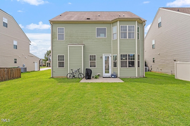 back of house featuring a lawn, a patio area, and central AC