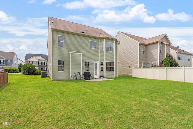 rear view of house with a yard and central AC