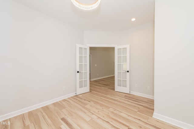 spare room featuring light hardwood / wood-style flooring and french doors