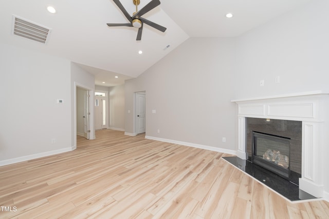 unfurnished living room featuring a fireplace, high vaulted ceiling, ceiling fan, and light wood-type flooring