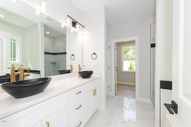 bathroom featuring tile patterned flooring, an enclosed shower, and vanity