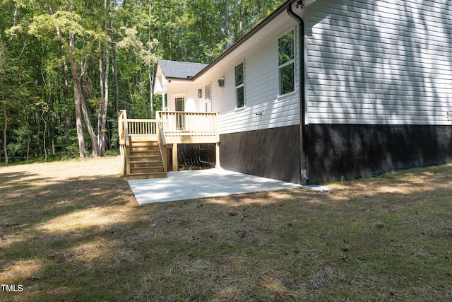 view of home's exterior with a wooden deck and a patio