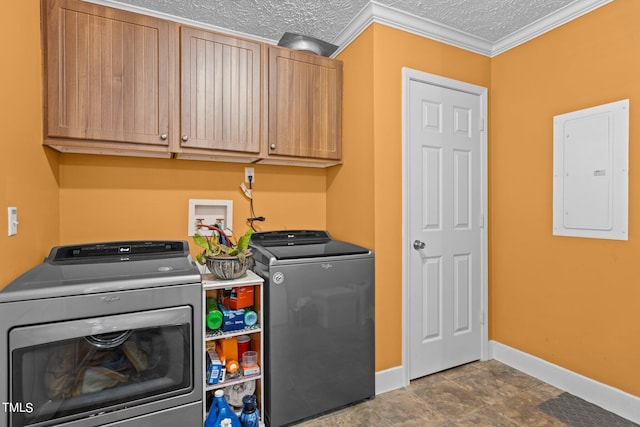 clothes washing area with dark tile patterned floors, electric panel, washing machine and dryer, crown molding, and cabinets