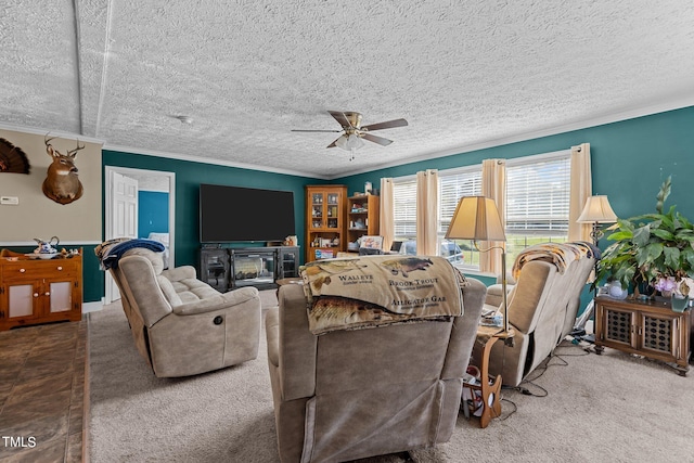 carpeted living room featuring a textured ceiling, ceiling fan, crown molding, and a fireplace