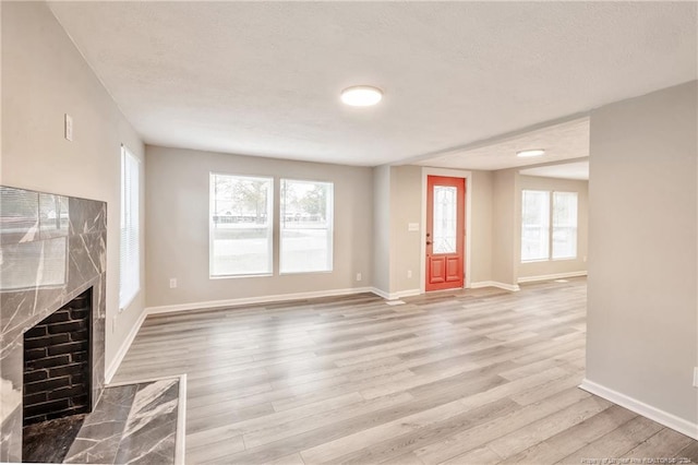 unfurnished living room with a high end fireplace and wood-type flooring