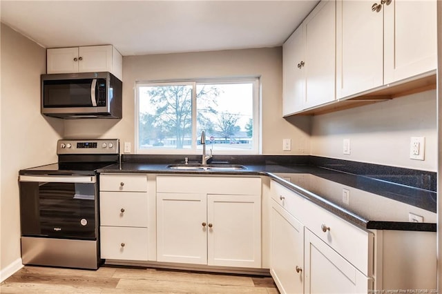 kitchen with light hardwood / wood-style flooring, stainless steel appliances, white cabinetry, and sink