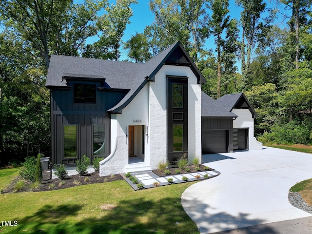 view of front of house featuring board and batten siding, an attached garage, a shingled roof, and a front yard