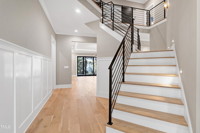 staircase featuring ornamental molding and wood-type flooring