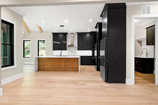 kitchen with backsplash, crown molding, wall chimney exhaust hood, and decorative light fixtures