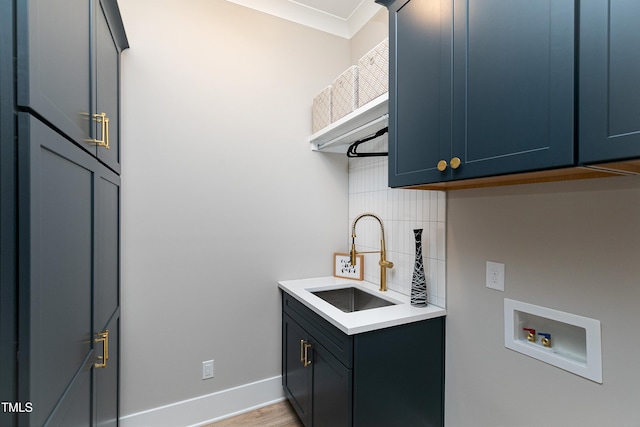 laundry area featuring cabinets, hookup for a washing machine, sink, and light hardwood / wood-style floors