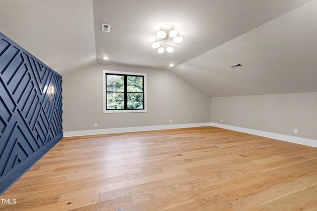 additional living space with light wood-type flooring and vaulted ceiling