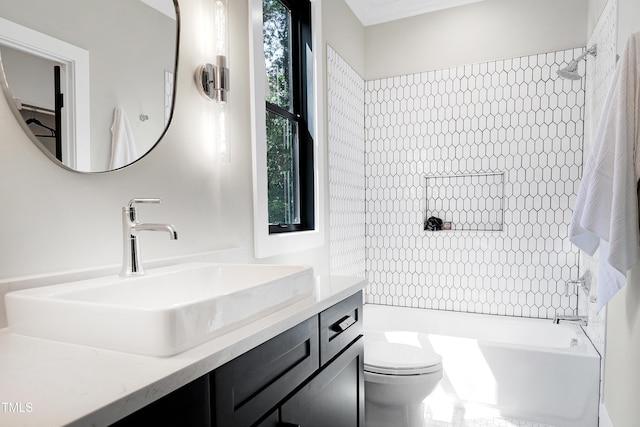 full bathroom featuring vanity, tiled shower / bath combo, and toilet