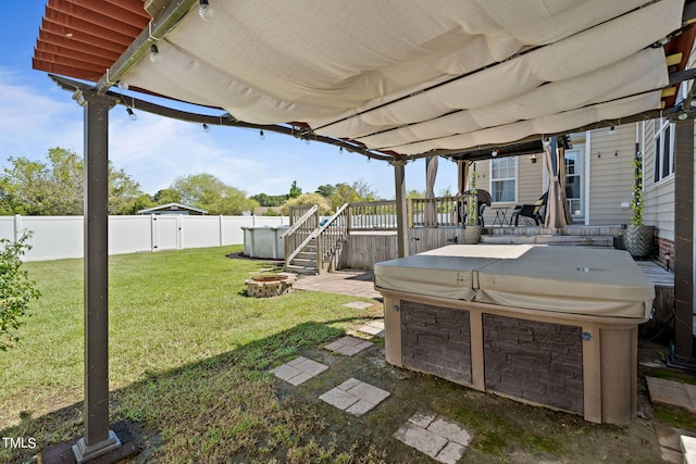 view of yard with a hot tub, a deck, and an outdoor fire pit