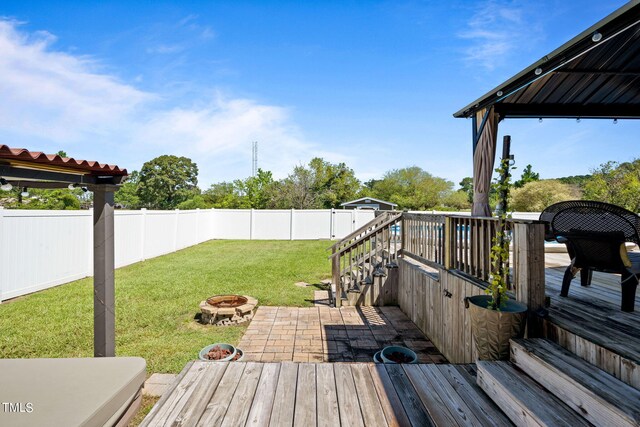 wooden deck featuring a yard and a fire pit