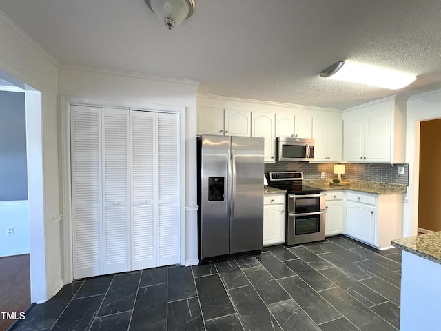 kitchen featuring stainless steel appliances, ornamental molding, white cabinets, and backsplash