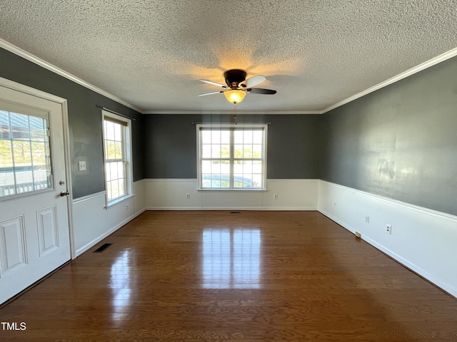 empty room featuring crown molding, plenty of natural light, and dark hardwood / wood-style floors