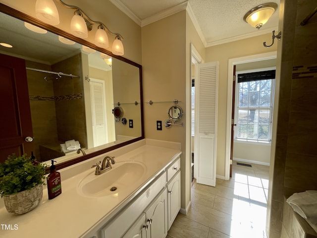 bathroom featuring vanity, tile patterned floors, ornamental molding, and tiled shower