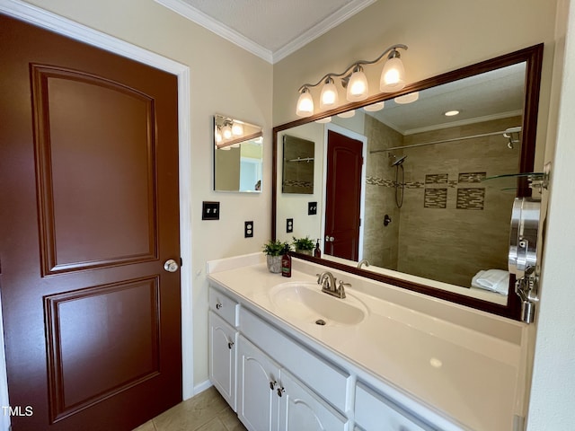 bathroom with tile patterned flooring, ornamental molding, tiled shower, and vanity