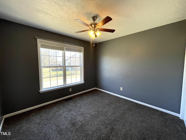 carpeted spare room featuring ceiling fan and a textured ceiling