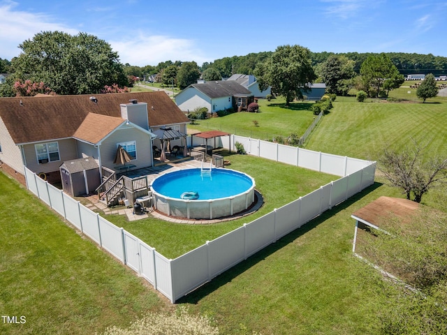 view of swimming pool featuring a yard, a fenced backyard, a fenced in pool, and a wooden deck