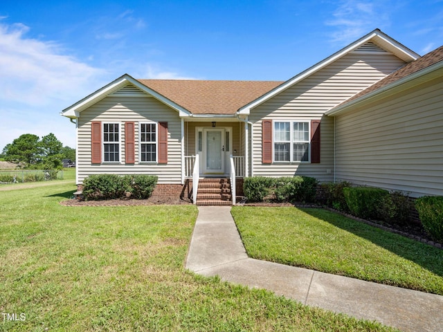 ranch-style house with a shingled roof and a front yard