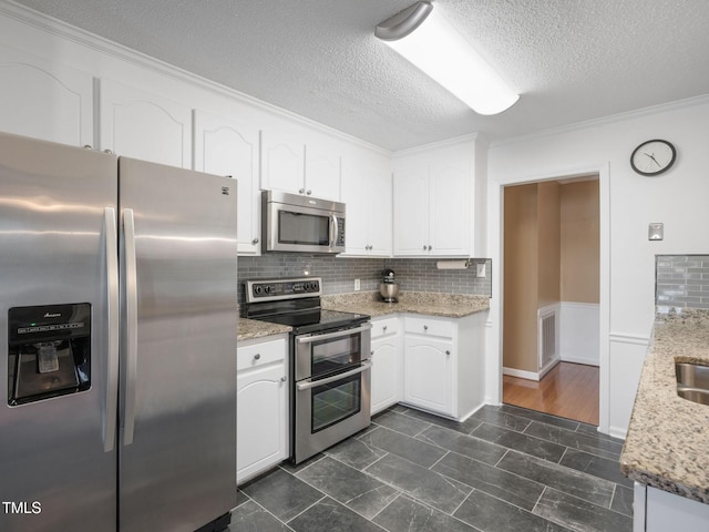 kitchen featuring decorative backsplash, white cabinets, and stainless steel appliances