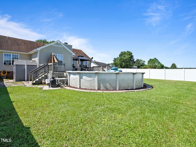 view of yard featuring a deck, fence, and an outdoor pool