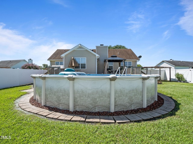 back of house featuring a fenced in pool, a yard, a chimney, a gazebo, and fence private yard