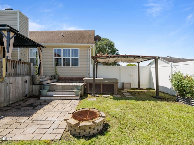 back of property featuring fence, a yard, a fire pit, roof with shingles, and a patio area