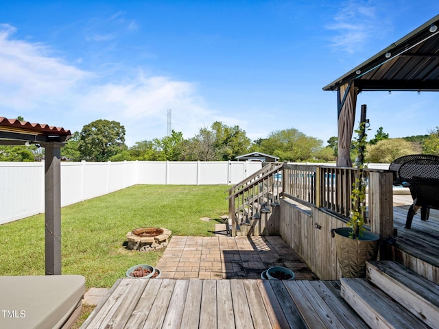 wooden deck featuring a patio area, a lawn, a fire pit, and a fenced backyard