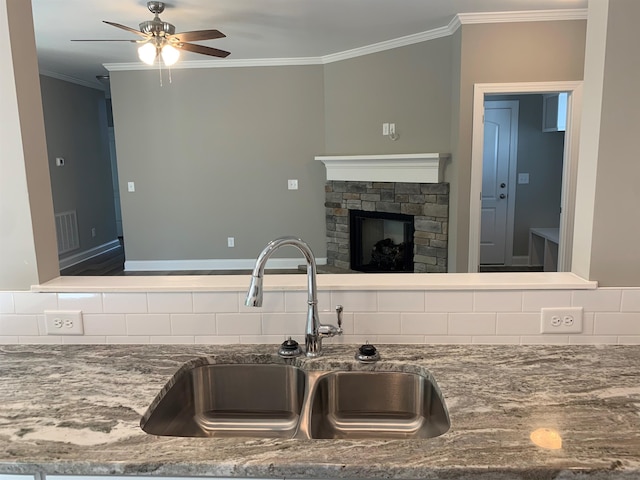 kitchen featuring ornamental molding, ceiling fan, sink, and decorative backsplash