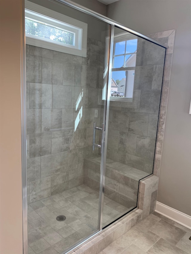 bathroom featuring a healthy amount of sunlight, an enclosed shower, and tile patterned floors