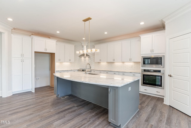 kitchen featuring white cabinets, an island with sink, appliances with stainless steel finishes, and dark wood-type flooring