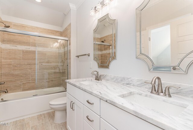 full bathroom with vanity, toilet, crown molding, and enclosed tub / shower combo