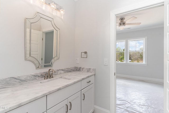 bathroom with baseboards, vanity, a ceiling fan, and crown molding